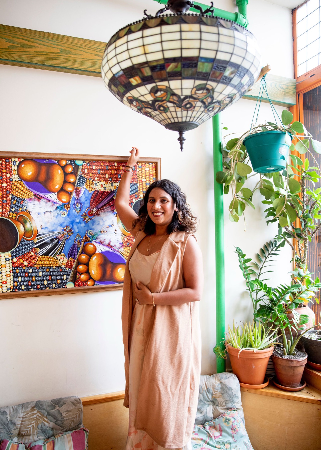 Tanisha standing with one arm raised, holding the room