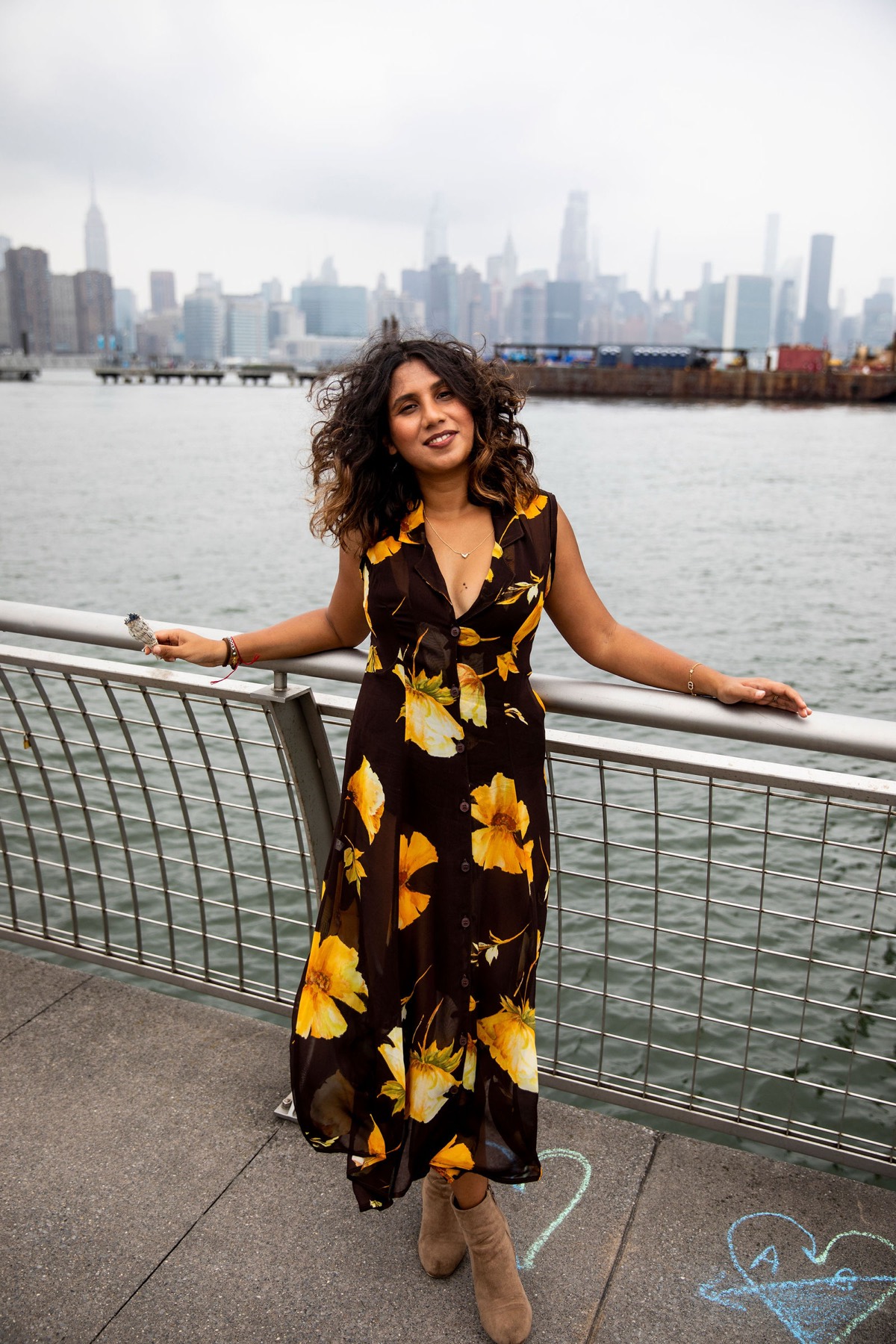 Tanisha by the river railing, wind in her hair, calm and smiling